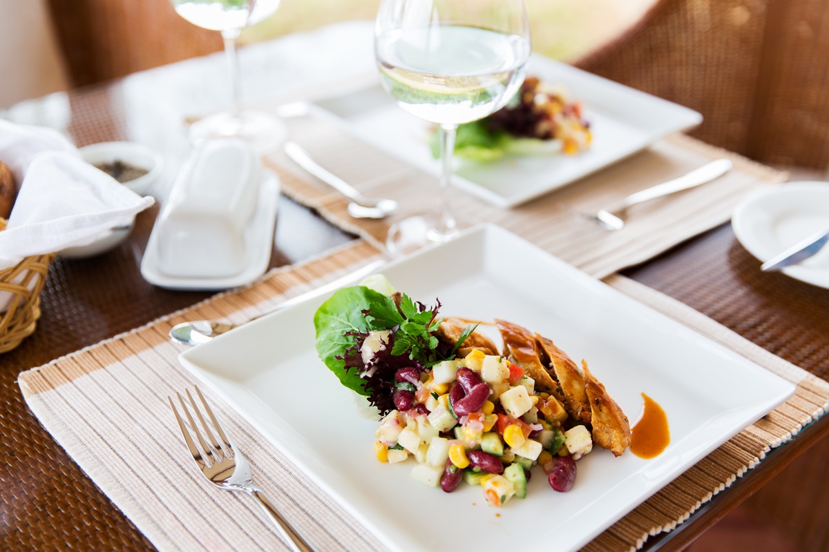 food, dinner and eating concept - vegetable salad with meat on plate and glasses of water at restaurant